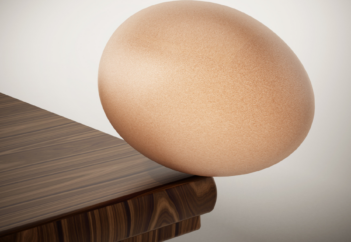 Egg teetering on edge of table